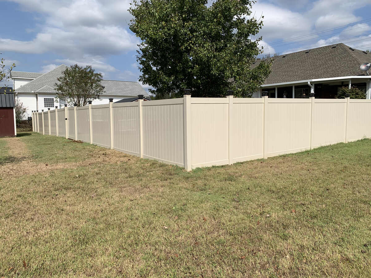 Cream vinyl fence installed in a backyard by Master Fence