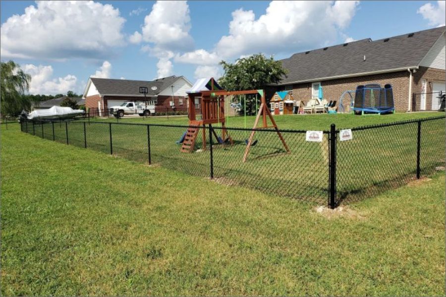 Small black chain link fence for a families home.